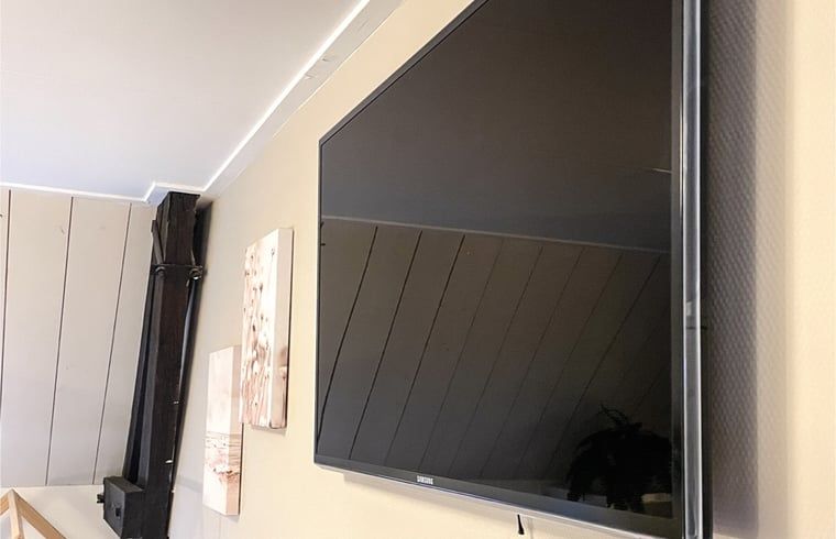 Moderner Fernseher an der Wand im Ferienhaus in De Cocksdorp, Texel.