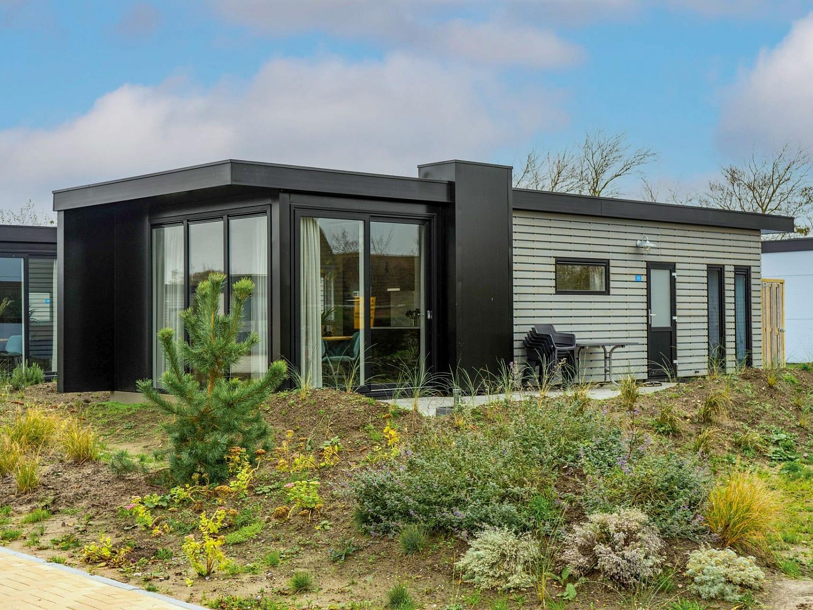 Ferienhaus Pavilion 4 in De Cocksdorp, Texel, umgeben von natuerlichen Gaerten und moderner Architektur auf den Watteninseln.