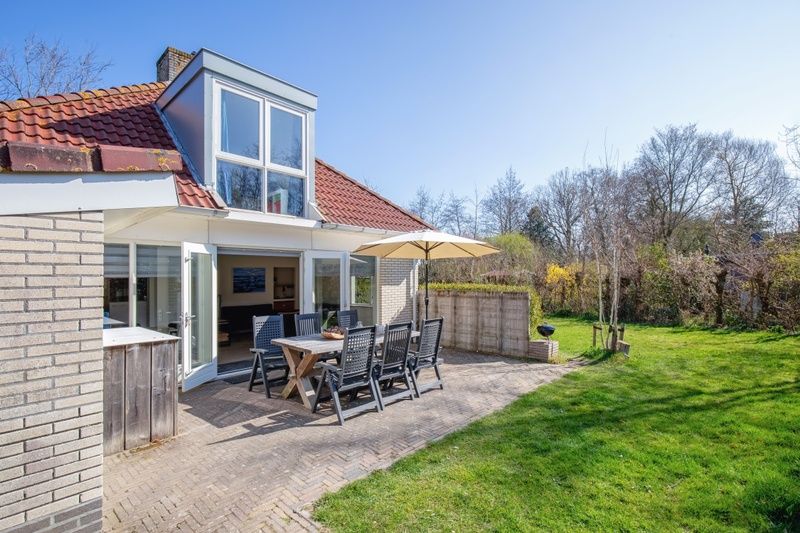 Terrasse mit Sitzgelegenheit im Bungalowpark Slufterduin - 't Oppertje, Ferienhaus in De Cocksdorp, Texel, umgeben von Natur.