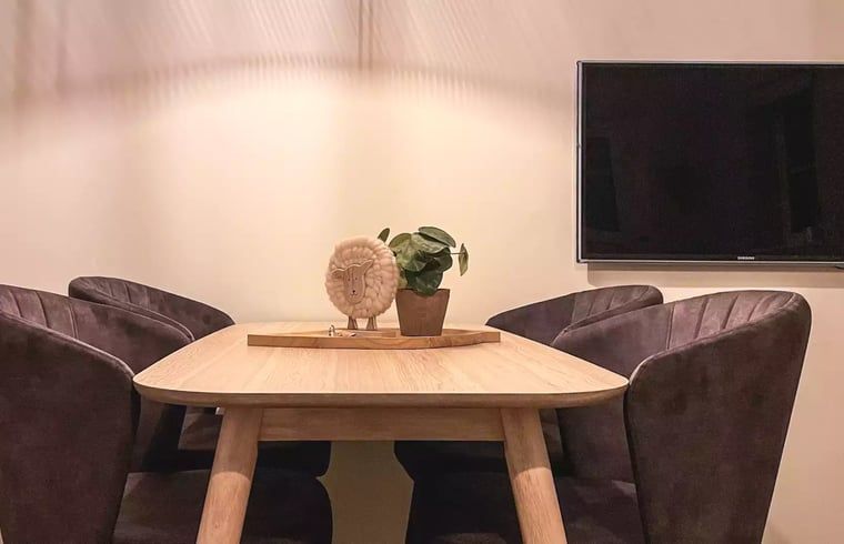 Eetruimte in Huisje in De Cocksdorp, Texel, met houten tafel en comfortabele stoelen voor gezellige diners.