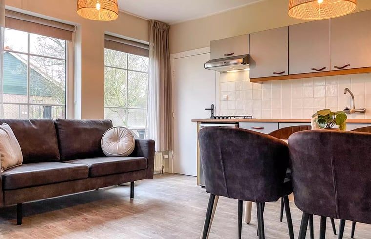 Gezellige woonkamer in Huisje in De Cocksdorp, Texel, met comfortabele bank en eethoek.