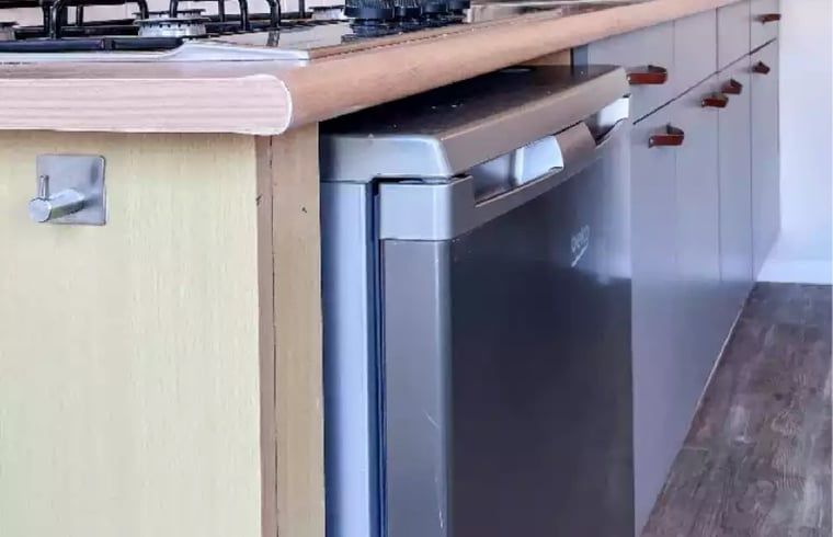 Keukenapparatuur in Huisje in De Cocksdorp, Texel, met moderne koelkast en kookplaat.