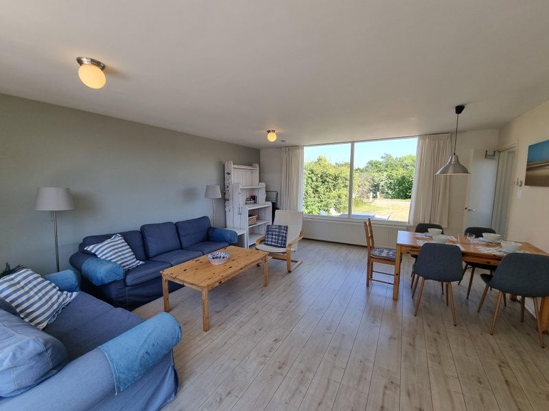 Geraeumiges Wohnzimmer des Bungalows 178 im Bungalowpark Tamarisk, De Cocksdorp Texel, mit grossen Fenstern und viel Licht.