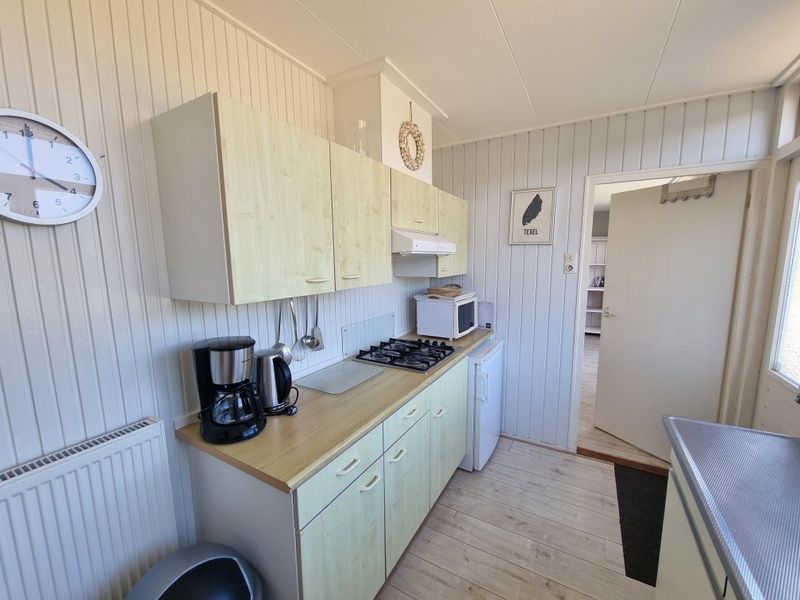 Kueche von Bungalow 178 im Bungalowpark Tamarisk Texel, De Cocksdorp, mit praktischer Einrichtung und Geraeten.