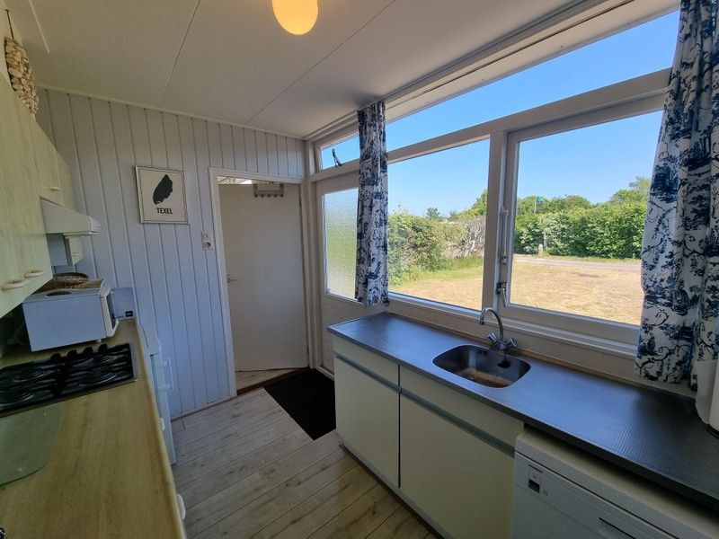 Helle Kueche des Bungalows 178 im Bungalowpark Tamarisk, De Cocksdorp Texel, mit Blick auf den Garten.