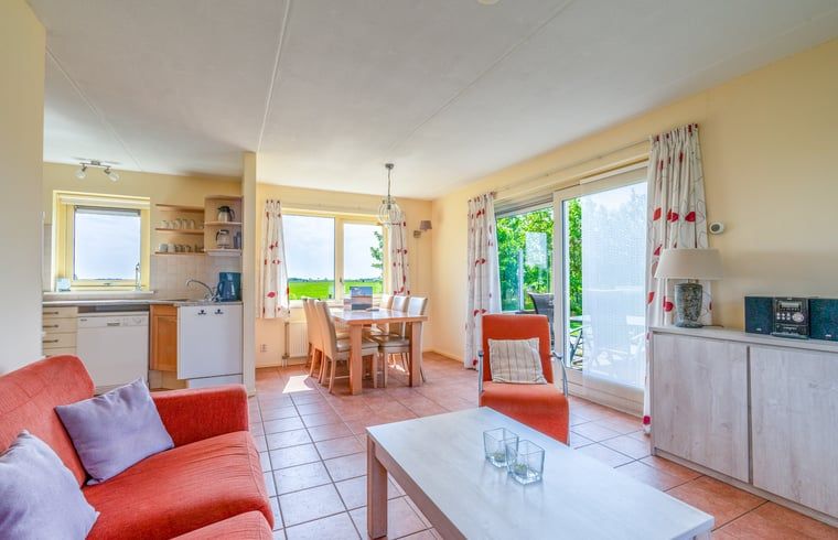 Helles Wohn- und Esszimmer im Ferienhaus in De Cocksdorp Texel mit Blick auf die Natur.