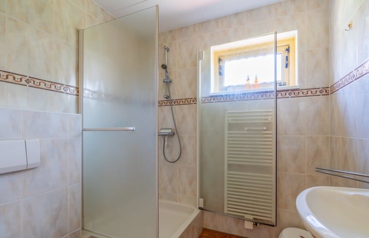 Badezimmer im Ferienhaus in De Cocksdorp Texel mit Dusche und Waschbecken.