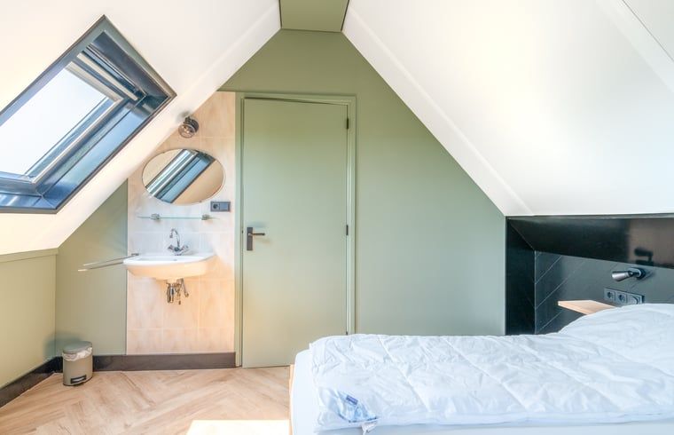 Schlafzimmer mit Dachfenster im Ferienhaus in De Cocksdorp Texel fuer natuerliches Licht.