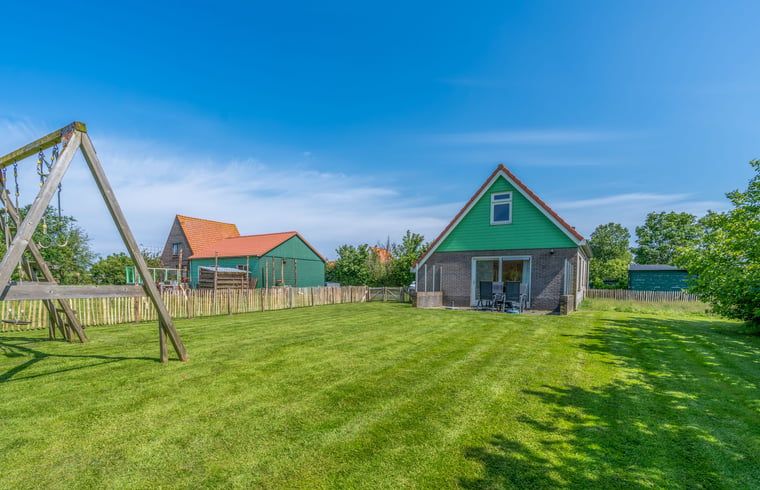 Geraeumiger Garten am Ferienhaus in De Cocksdorp Texel mit Spielgeraeten fuer Kinder.