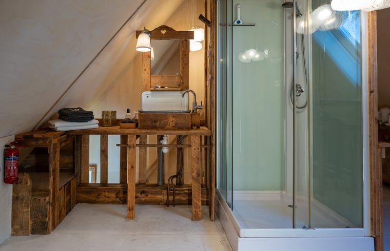 Aussenbereich des Ferienhauses in De Cocksdorp, Texel, mit Sonnenkollektoren und laendlichem Charme.