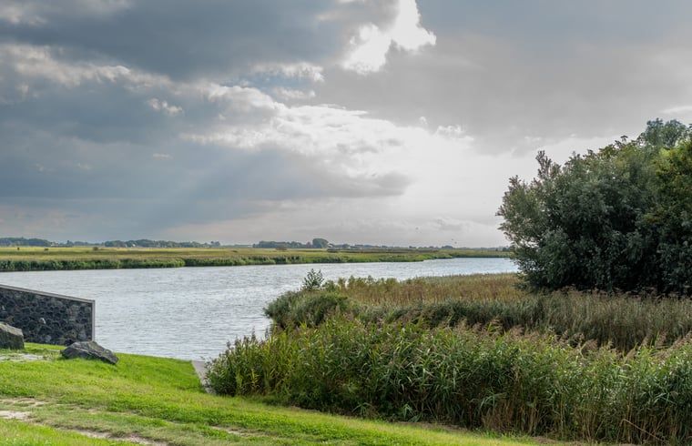 Der Blick durch das Holzfenster auf die Landschaft im Ferienhaus in De Cocksdorp, Texel, bietet einzigartige Perspektiven.