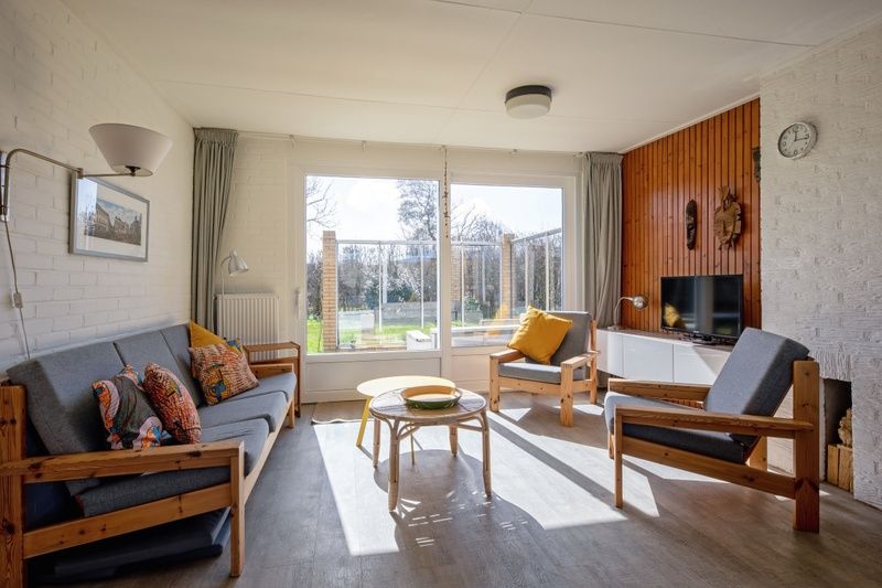 Helles Wohnzimmer im Ferienhaus Slufteroord 292 mit Blick auf den Garten in De Cocksdorp, Texel.