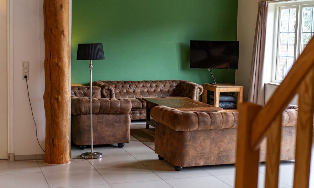 Gemuetliches Wohnzimmer des Ferienhauses Paal 86 Texel in De Cocksdorp mit Ledersofas.