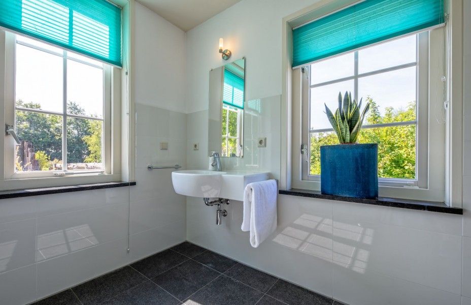 Helles Badezimmer im Ferienhaus Paal 86 Texel in De Cocksdorp mit Blick auf den Garten.