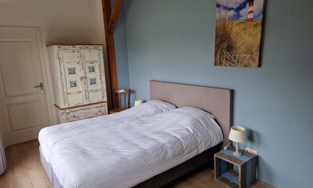 Helles Schlafzimmer im Ferienhaus Paal 86 Texel in De Cocksdorp mit Kunst an der Wand.