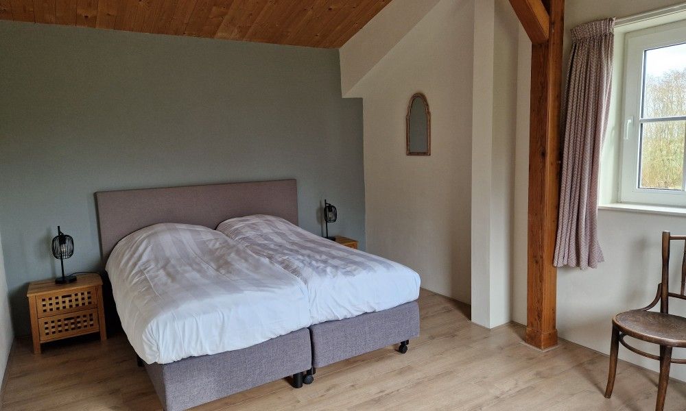 Komfortables Schlafzimmer in Paal 86 Texel Ferienhaus in De Cocksdorp mit Holzdetails.