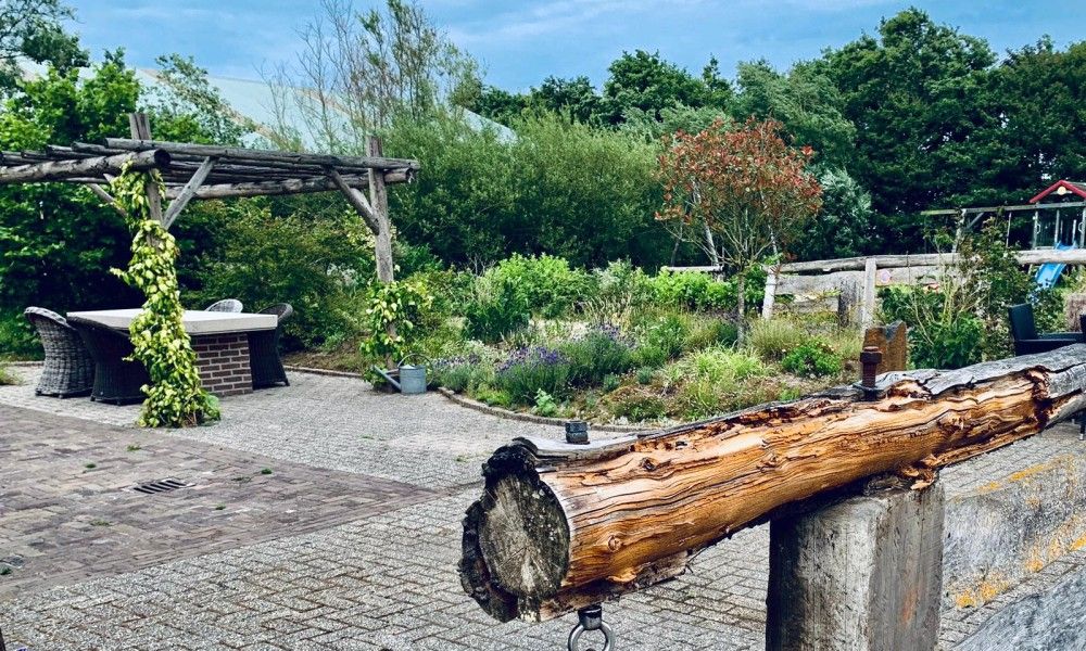 Gruener Garten am Ferienhaus Paal 86 Texel in De Cocksdorp mit Holzpergola.