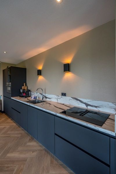 Moderne Kueche in einem 6-Personen-Ferienhaus in De Cocksdorp, Texel, mit glatter Oberflaeche.