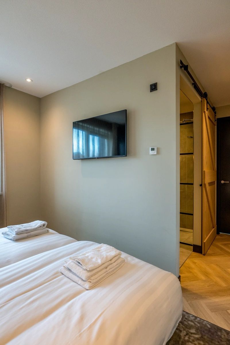 Schlafzimmer mit TV in einem 6-Personen-Ferienhaus in De Cocksdorp, Texel, idealer Erholungsraum.