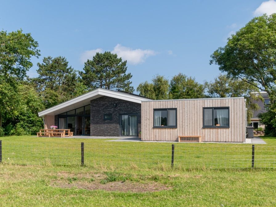 Orchismient 49 vacation home in De Koog, Texel with modern architecture and large terrace surrounded by nature.