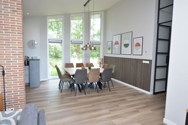 Dining area in Orchismient 49 vacation home, De Koog, Texel with large windows for stunning views of the surroundings.