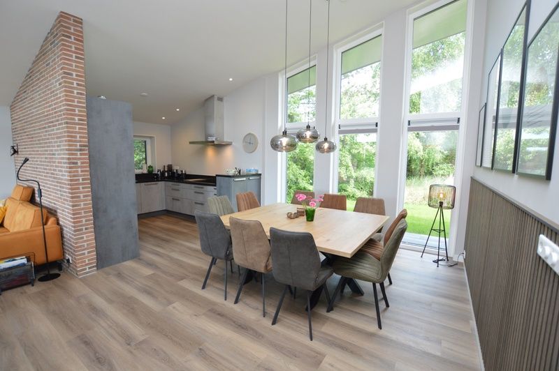 Spacious dining room of Orchismient 49 vacation home in De Koog, Texel with modern furnishings and lots of natural light.