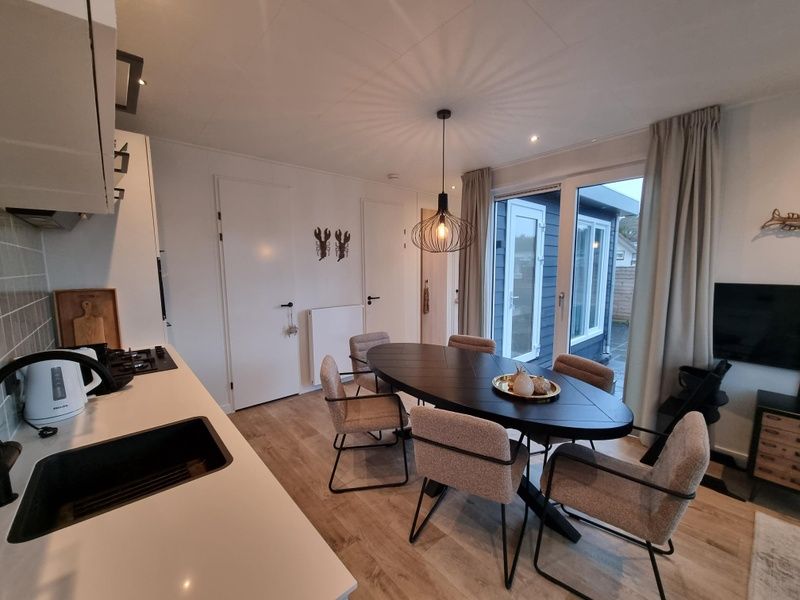Dining area and kitchen in Chalet Bregkoog 119, ideal for family dinners on Texel, De Koog, Wadden Islands.