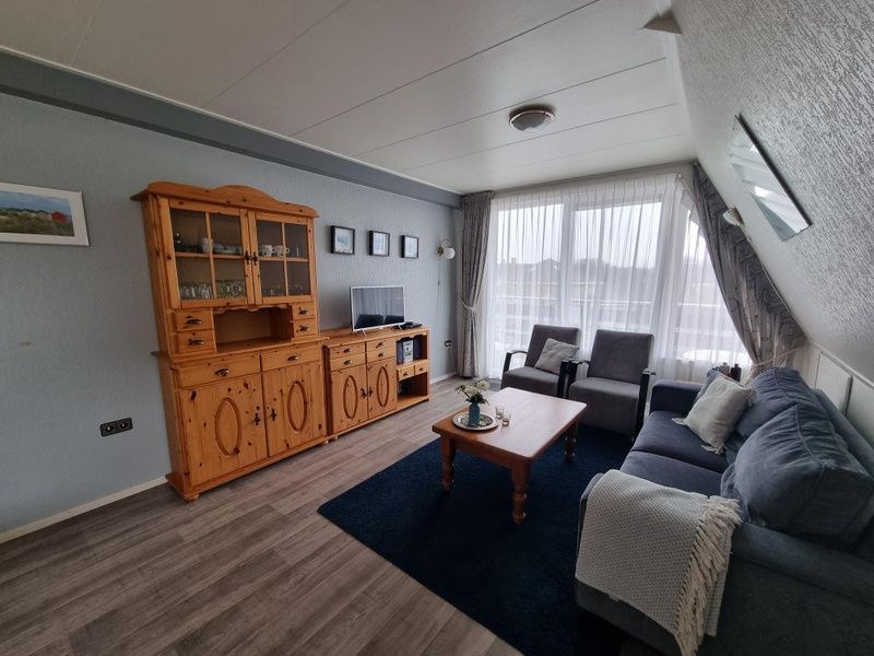Gemuetliches Wohnzimmer in Appartements Anna - Noorderlicht - 13, De Koog, Texel, mit bequemer Sitzecke und viel Tageslicht.