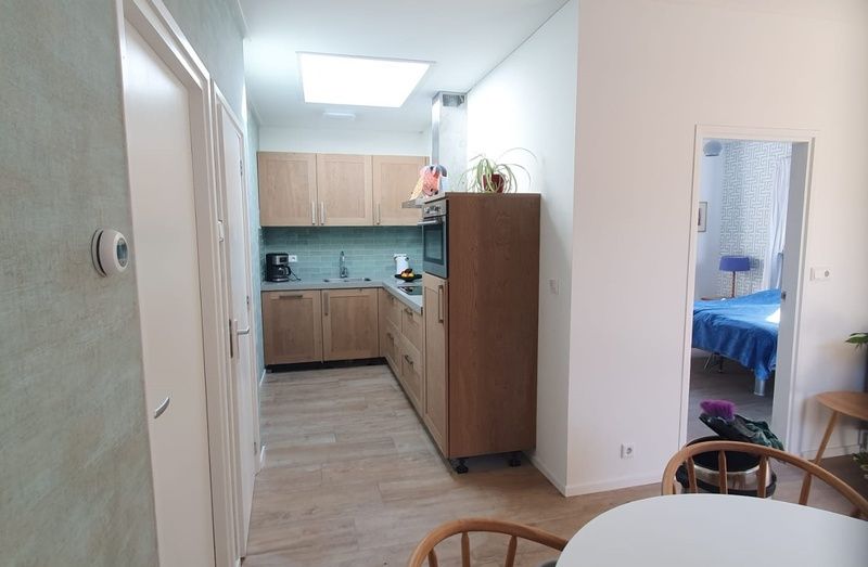 Modern kitchen in vacation home Huisje Quirijn, De Koog Texel with wooden cabinets and light through skylight.