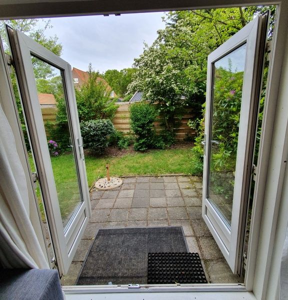 View of the green garden of Huisje Quirijn, De Koog Texel from the cottage's French doors.