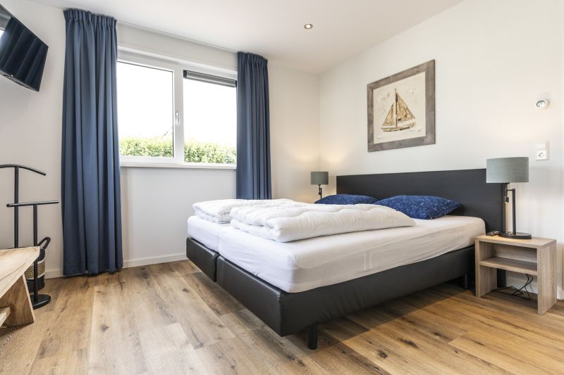 Comfortable bedroom in Villa 41, De Koog, Texel, with large window and restful atmosphere.