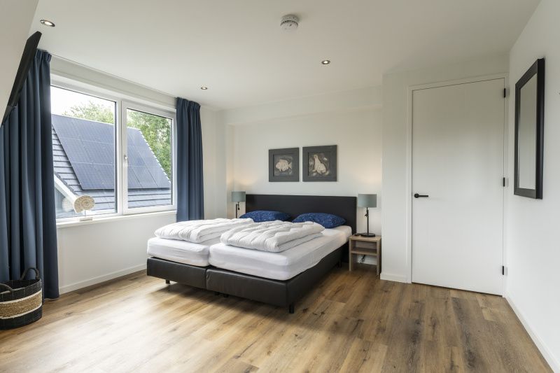 Spacious bedroom in Villa 41, De Koog, Texel, with views of the Wadden Islands surroundings.