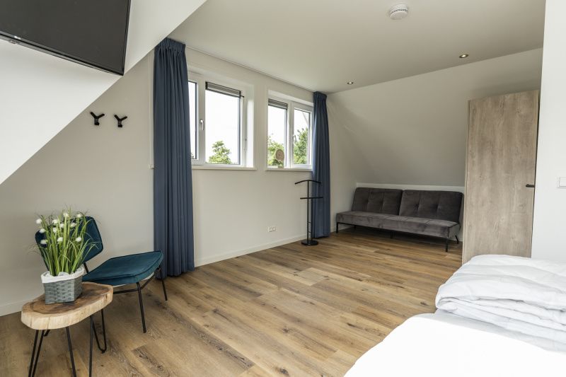 Extra spacious room in Villa 41, De Koog, Texel, with sitting area and modern furnishings.