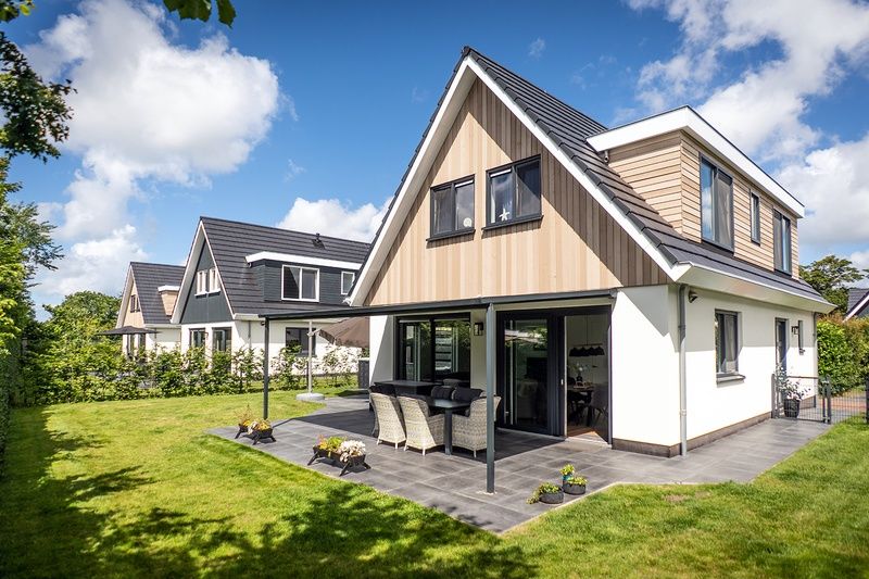 Rear view of Villa 41 in De Koog, Texel, with terrace and green surroundings on the Wadden Islands.