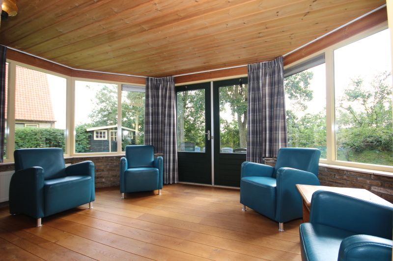 Veranda of Landhuis Landleven No. 81, vacation home in De Koog, Texel overlooking green surroundings.