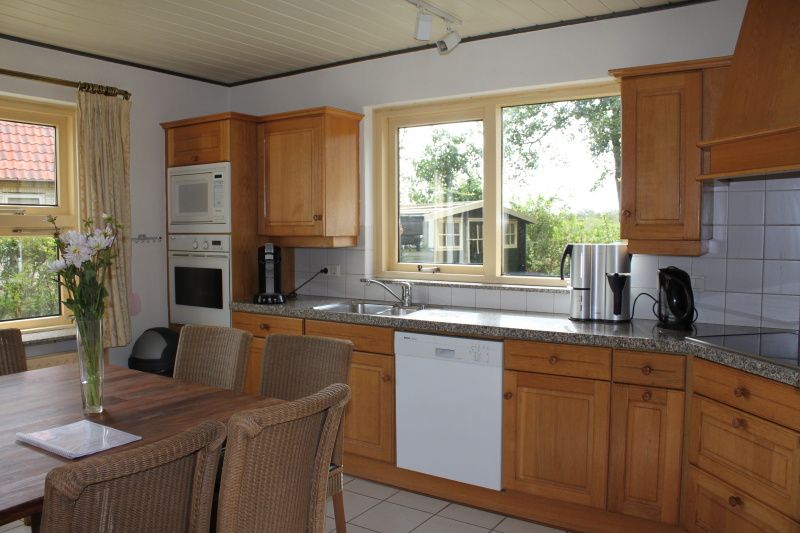 Kitchen of Landhuis Landleven No. 81, vacation home in De Koog, Texel with modern amenities and dining area.
