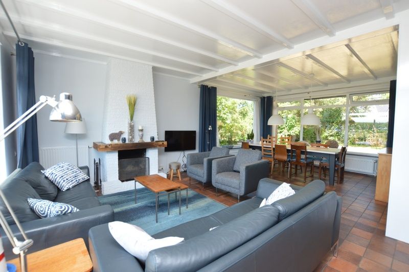 Gemuetliches Wohnzimmer in Orchismient 45 grosses Ferienhaus De Koog Texel mit bequemen Sitzgelegenheiten und Kamin.