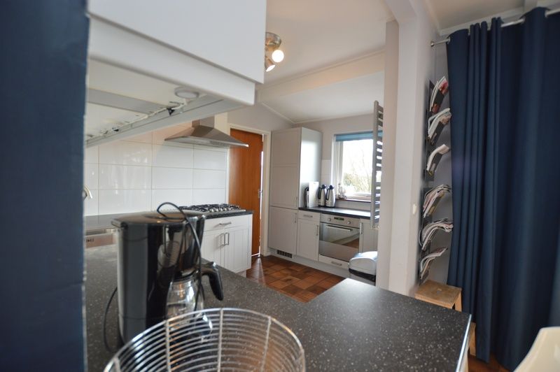 Gut ausgestattete Kueche in Orchismient 45 grosses Ferienhaus De Koog Texel mit Blick auf den Garten.