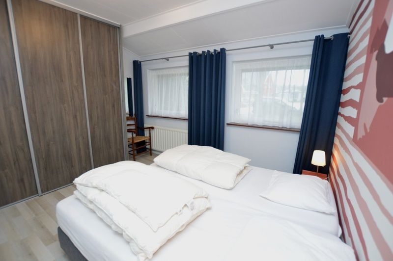 Gemuetliches Schlafzimmer in Orchismient 45 grosses Ferienhaus De Koog Texel mit grossen Fenstern und viel Stauraum.