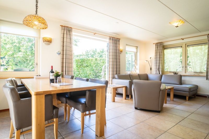 Dining room in Villa, De Koog, Texel with large table and view of green surroundings.