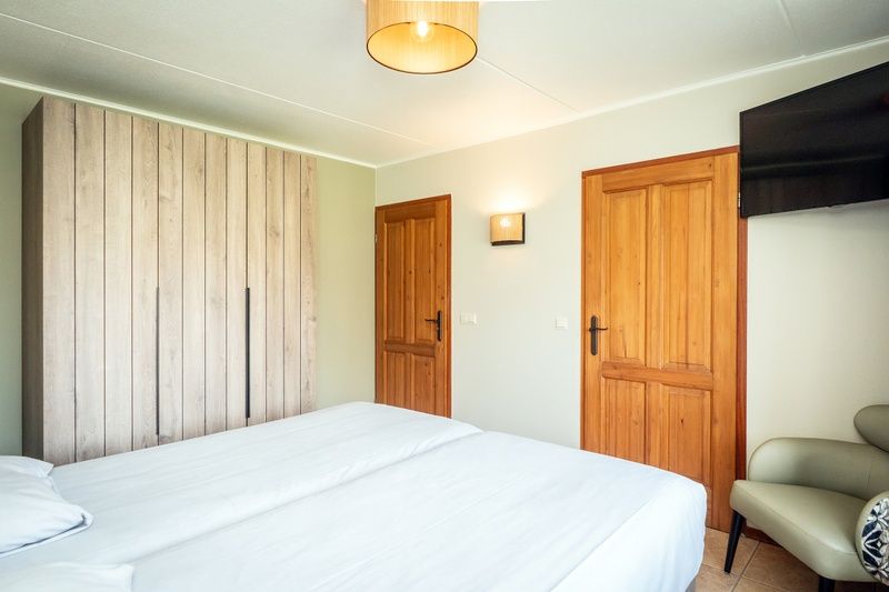Bedroom in Villa, De Koog, Texel with spacious closet and wooden doors for a warm atmosphere.