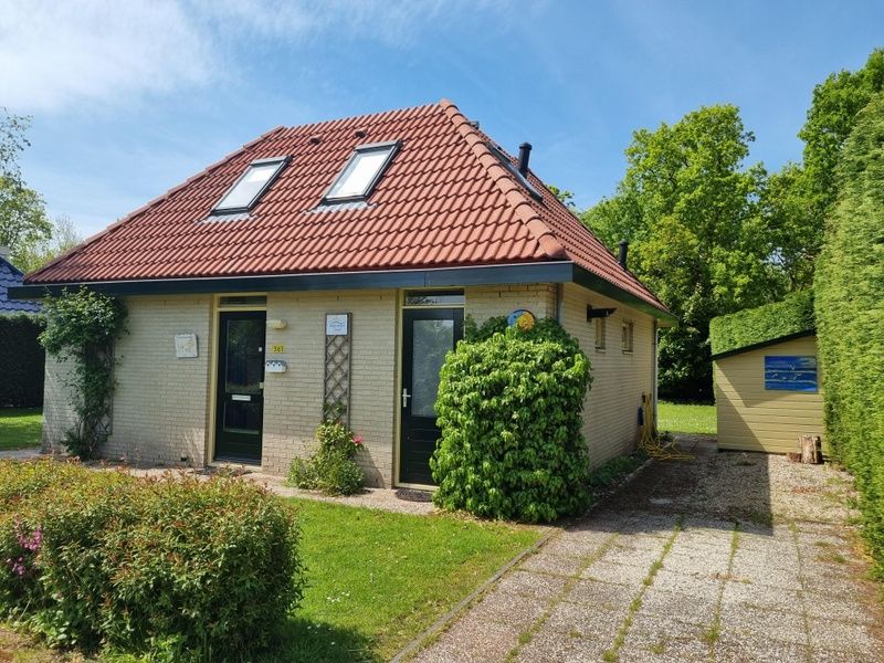 Entrance to Residence California - Geborchenheit - 361, vacation home on Texel, with red tile roof and lush garden.