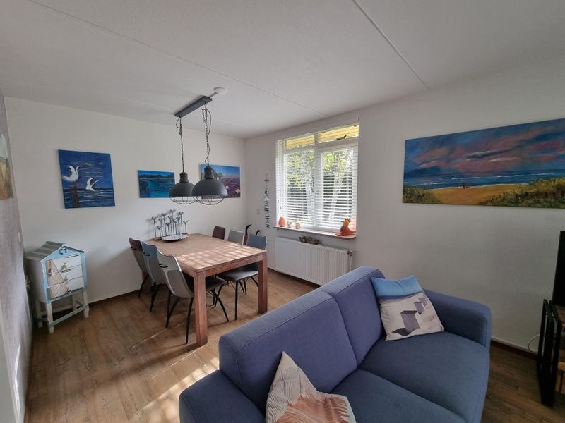 Dining room of Residence California - Geborchenheit - 361 in De Koog, Texel, with wooden table and art on the wall.
