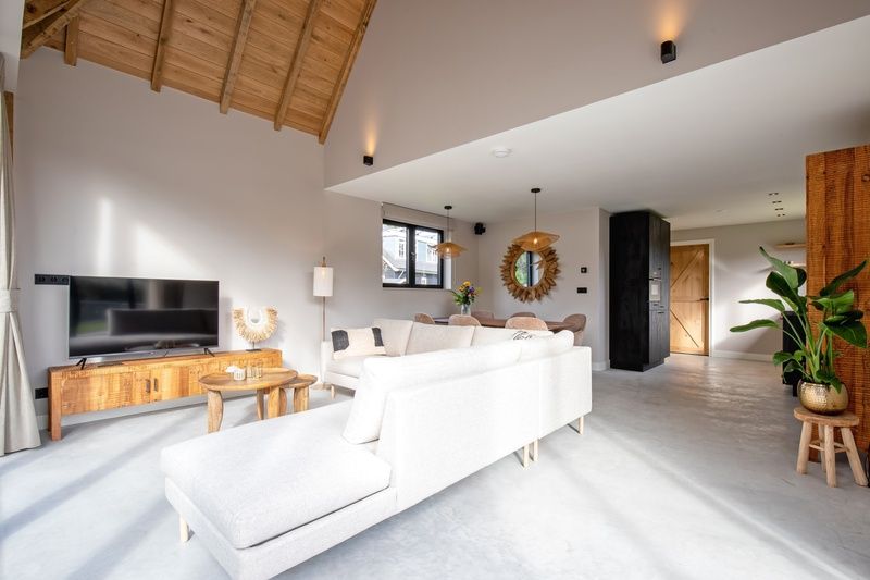 Spacious living room of Villa Flo, Texel with comfortable sofa and entertainment options.