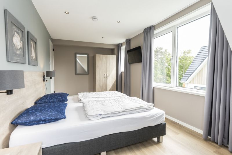 Villa 17, De Koog, Texel has a sunny terrace with comfortable seating and garden views for outdoor fun.