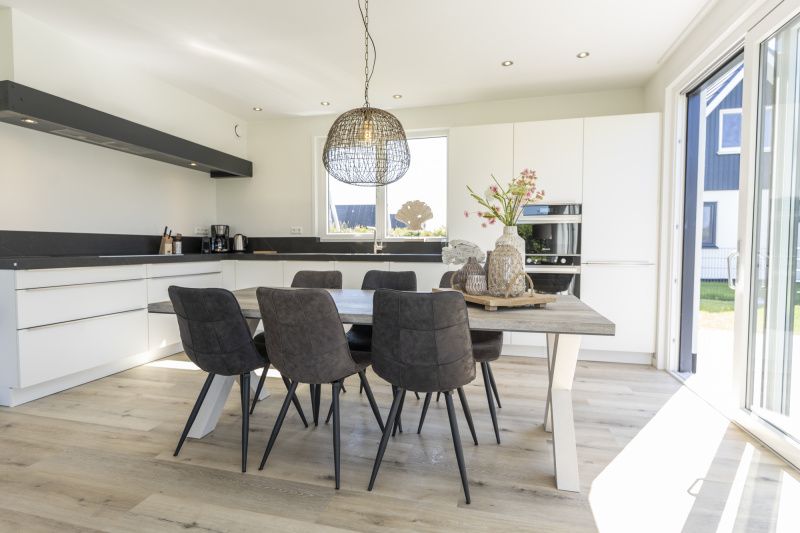 Dining room in Villa 35a, De Koog, Texel with modern kitchen and large table.
