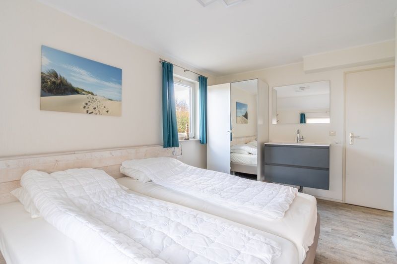 Bedroom in vacation home Honeysuckle 81, De Koog, Texel with double bed and fresh furnishings, ideal for a good night's sleep.