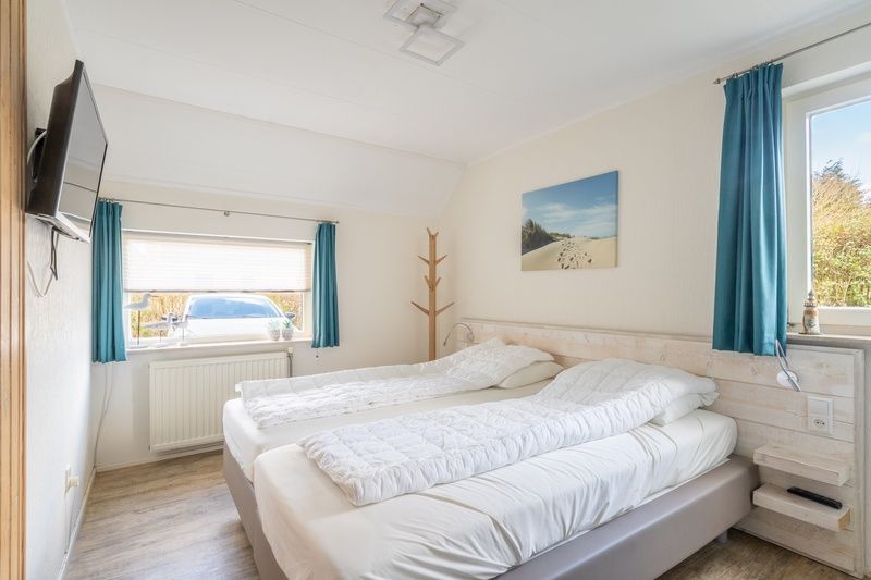 Bright bedroom of vacation home Honeysuckle 81, De Koog, Texel with comfortable bed and modern furnishings for a relaxing stay.