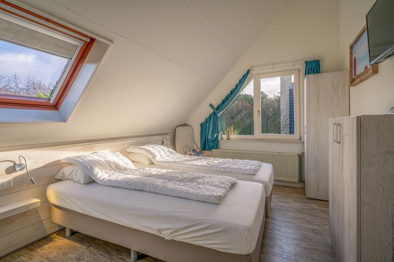 Cozy bedroom in vacation home Honeysuckle 81, De Koog, Texel with skylight and double bed, perfect for rest and relaxation.