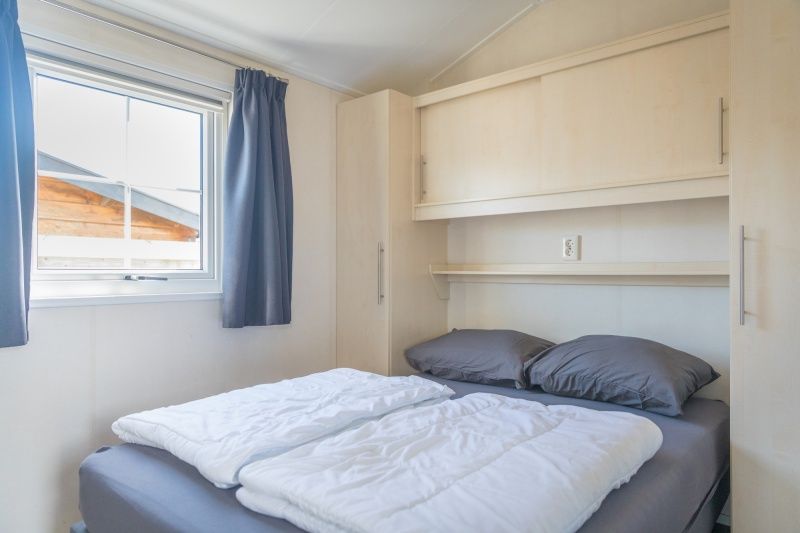Comfortable bedroom in Chalet Bregkoog 227, Chaletpark Bregkoog, De Koog, Texel with double bed and storage space.